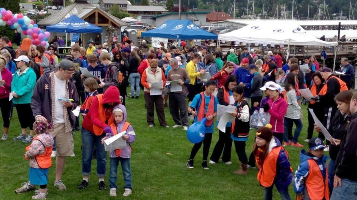 Participants in a previous Gig Harbor Street Scramble consult maps before heading out to find clues.