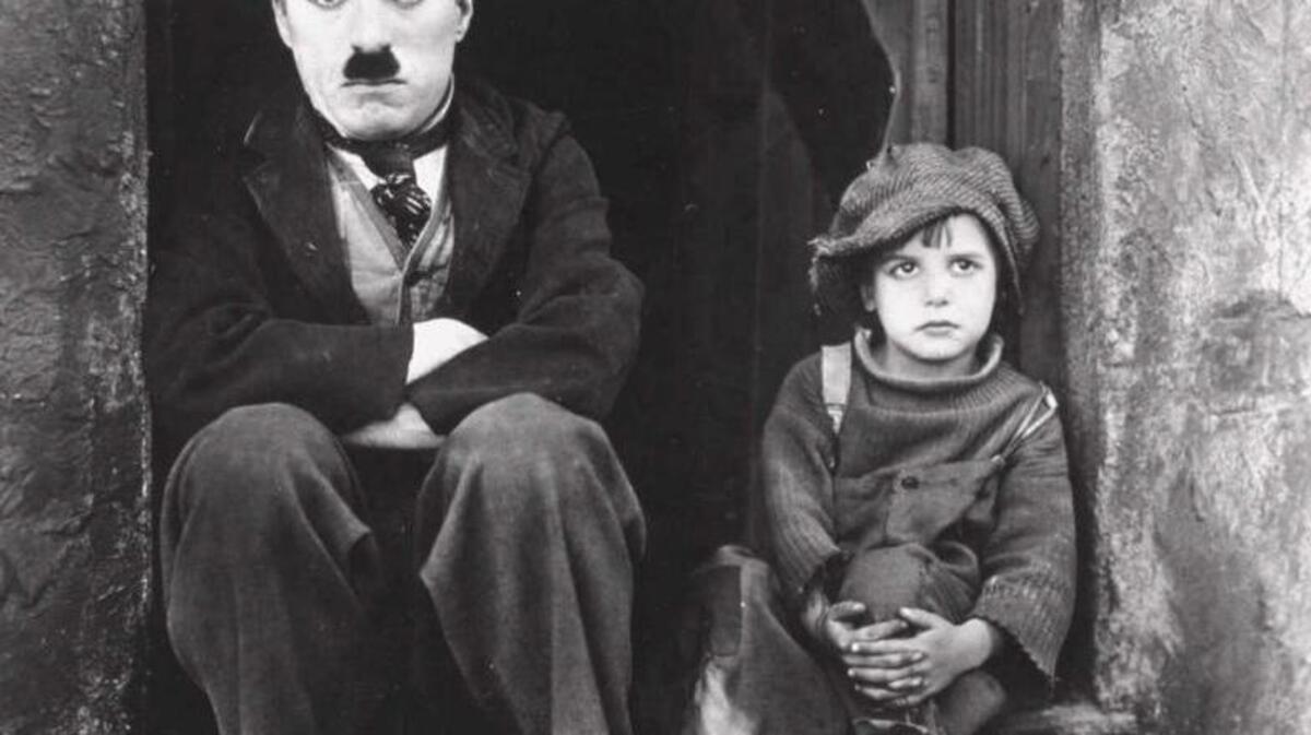 Charlie Chaplin, left, and Jackie Coogan appear in a scene from Chaplin’s 1921 silent film, “The Kid.”