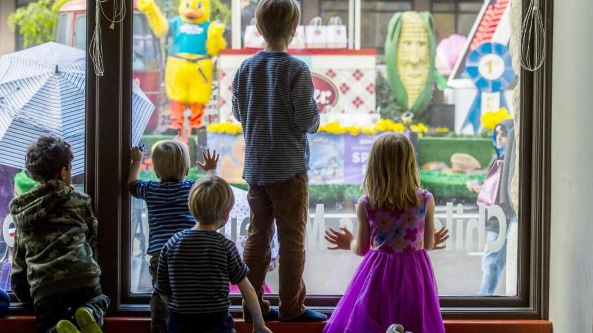 Kids watch from inside the Childrens Museum in the Daffodil Festival Grand Floral Parade in Tacoma, last year.