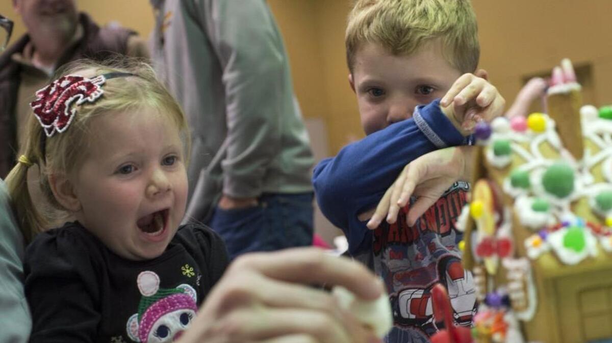 Gavin Grice, 6, right, wipes frosting from his mouth while constructing a ginger bread house with his sister Adri Grice, 3, at the annual Gingerbread Jamboree at the Hotel Murano's Bicentennial Pavilion in 2013. The Grice family of Gig Harbor were attending the event for the first time.