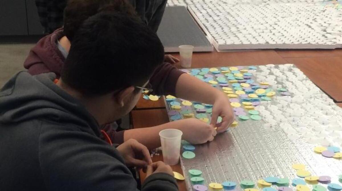 Artist Horatio Law, upper left, works with Lincoln High students on a collaborative piece for the upcoming arts event.
