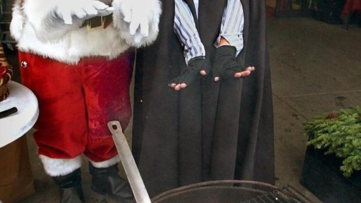Melissa Thayer, employee at Stadium Thriftway warms with Denny Faker (as Santa) as she roasts chestnut to sell to customers during the first Dickens Fest in 2005.