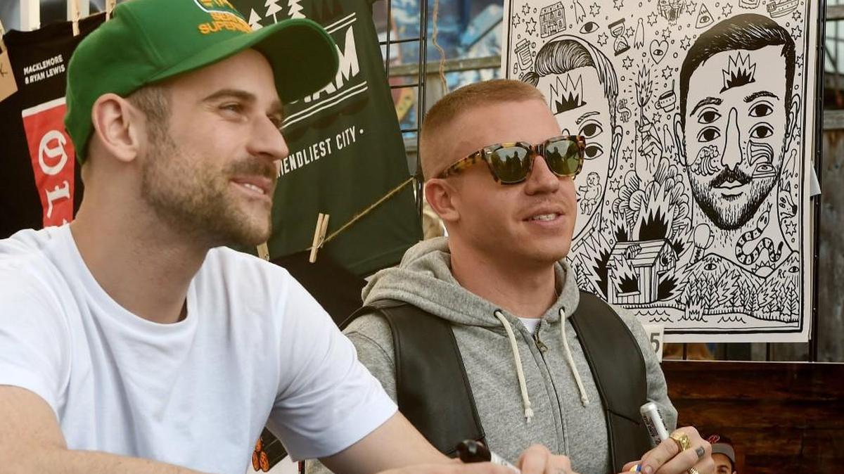 Throngs of fans greet hip hop recording artist Macklemore (right) and his musical partner Ryan Lewis as they sign autographs before a show at the Capitol Theater in downtown Olympia.