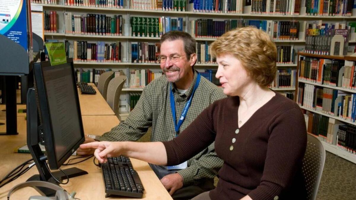 
Librarian Steve Lusasiak assists a patron seeking new employment at the job and business center at the South Hill branch of the Pierce County Library System. 
