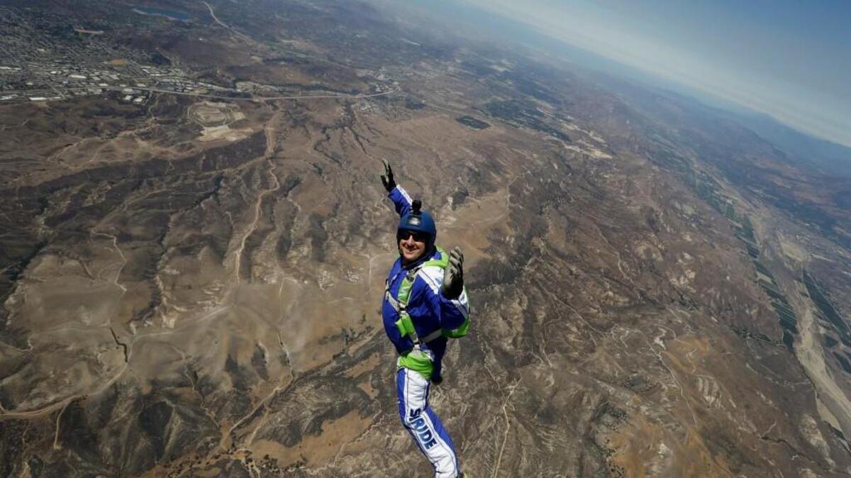 In this Monday, July 25, 2016 photo, skydiver Luke Aikins smiles as he jumps from a helicopter during his training in Simi Valley, Calif. After a two-minute freefall Saturday, Aikins landed dead center in the 100-by-100-foot net at the Big Sky movie ranch.