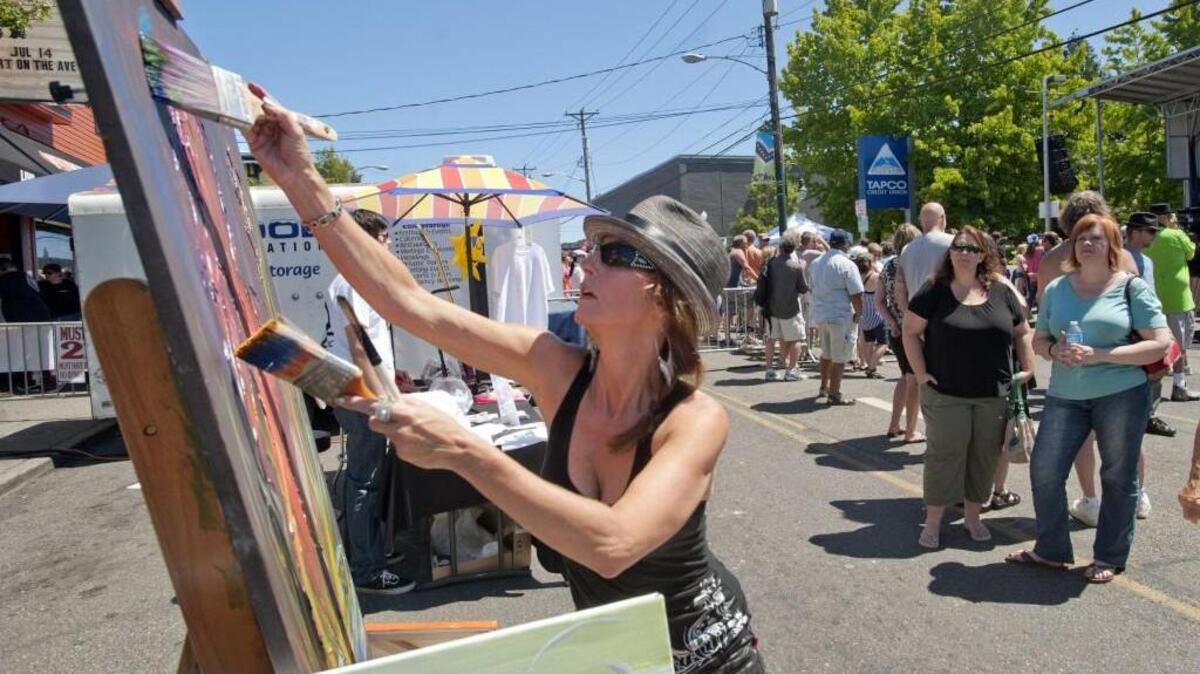 Teresa Oltman of Ashford paints with big strokes at Art on the Ave, an annual arts festival on Sixth Avenue in Tacoma, July 14, 2013.