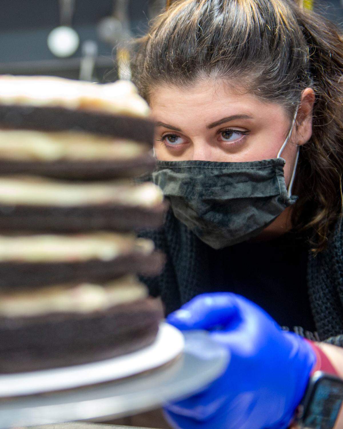 Terryn Abbitt, cake maker and co-owner of The Cat & Rabbitt Cake Shop, takes a good look at a seven-tiered peppermint chocolate cream cheese cake.