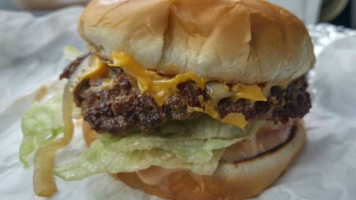 A cheeseburger at Jubilee Burgers comes with leaf iceberg lettuce and grilled onions.