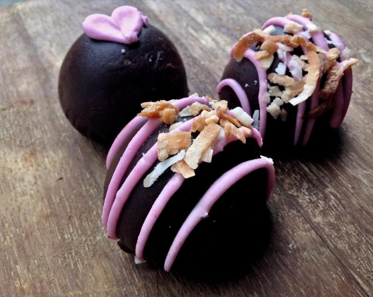 Truffles are chocolate dipped at Corina Bakery in Tacoma. Pictured here are coconut and praline truffles, in the display case for Valentine’s Day 2016.