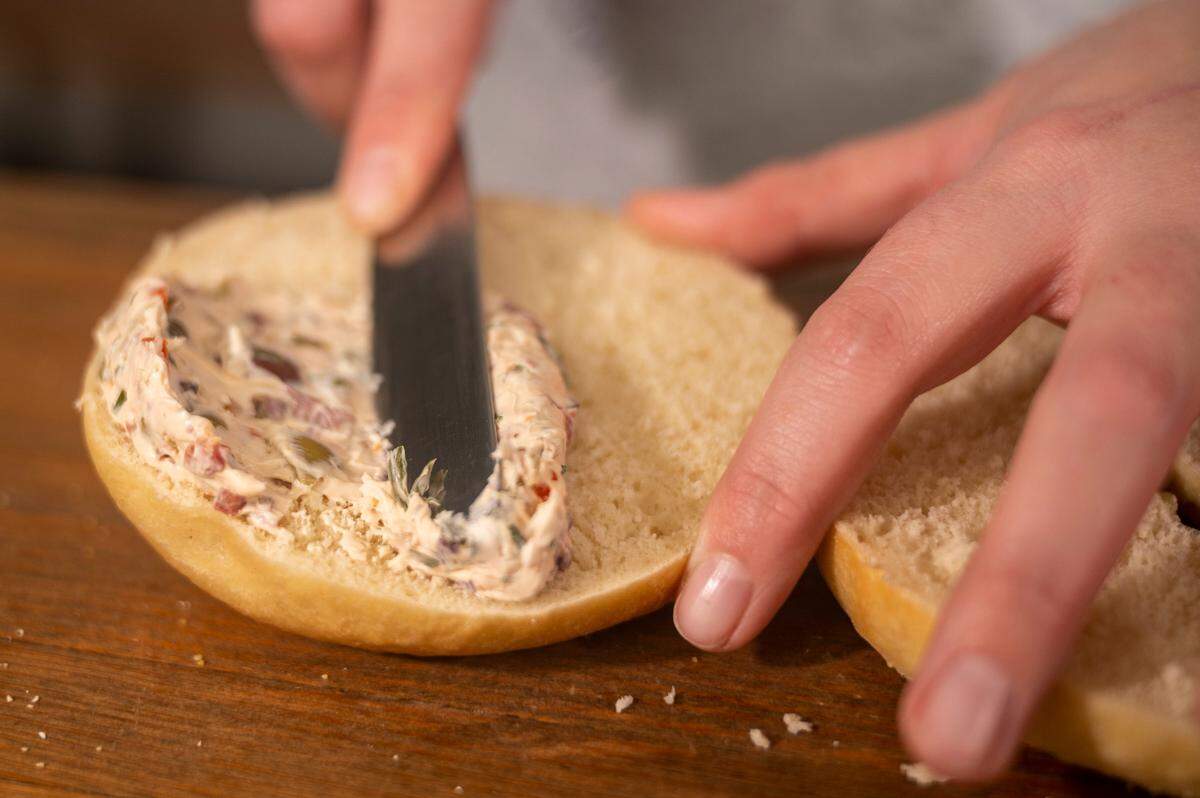 Brittany Erwin, owner of B’s Bagels and Butters in Gig Harbor, spreads a Giardiniera Cream cheese schmear onto a bagel.
