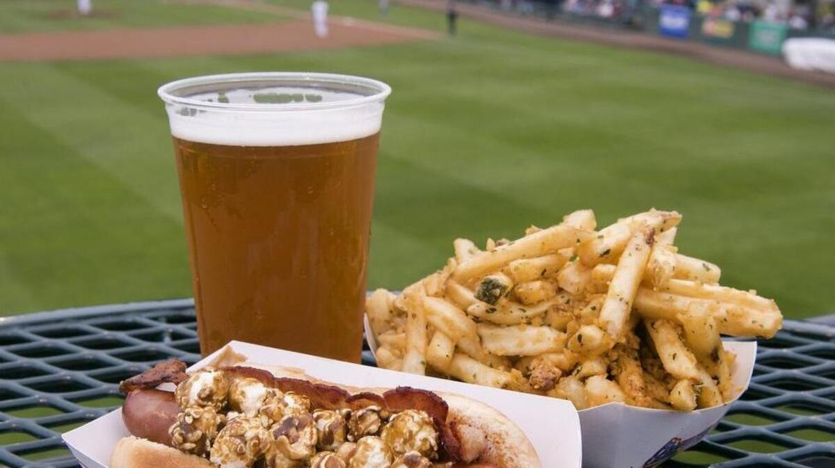 Ballpark food at the Rainiers' Cheney Stadium has some unique twists. Try a Cracker Jack Hot Dog from The Red Hot. It's a surprisingly tasty blend of peanut butter, bacon, all-beef hot dog and, yes, caramel-coated Cracker Jack popcorn. Or the breath-enhancing Grounders garlic fries from Fowl Territory. And then wash it down with a craft beer like this Bale Breaker IPA from The Red Hot.