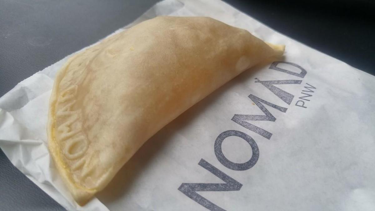 Nomad PNW stamps its empanadas with the name of the cafe.