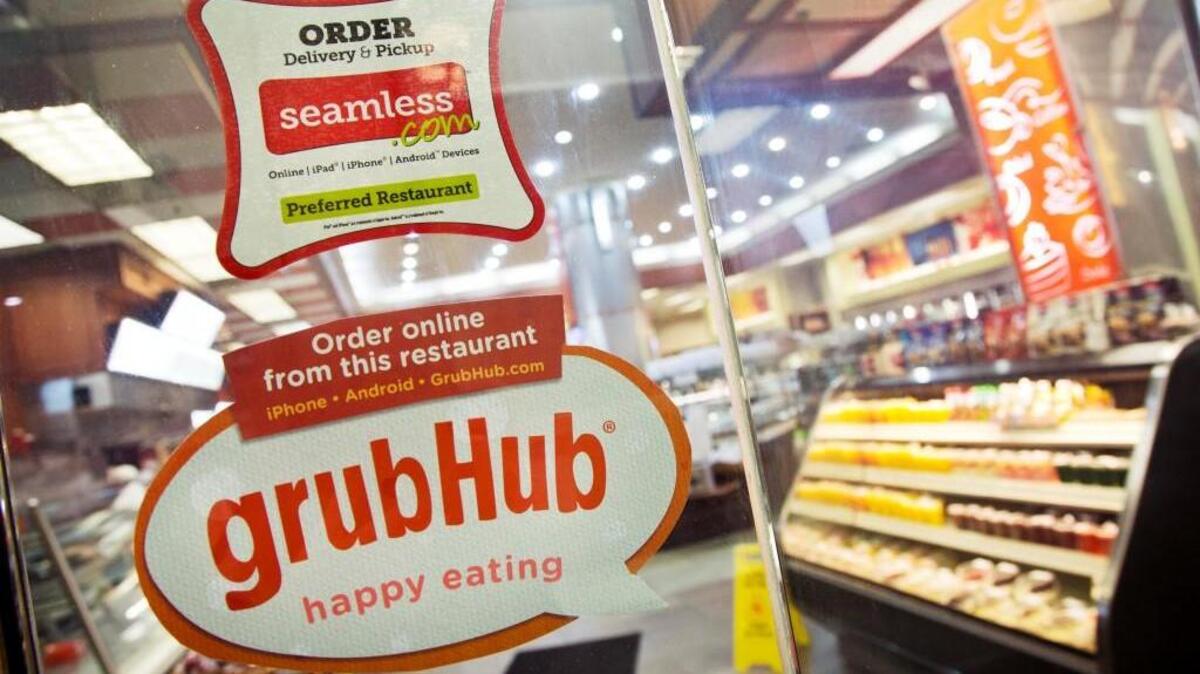 Signs for GrubHub and Seamless are displayed on the door to a New York restaurant, Friday, April 4, 2014. GrubHub, based in Chicago, also owns the Seamless food ordering website. It is now operating in Tacoma and University Place.