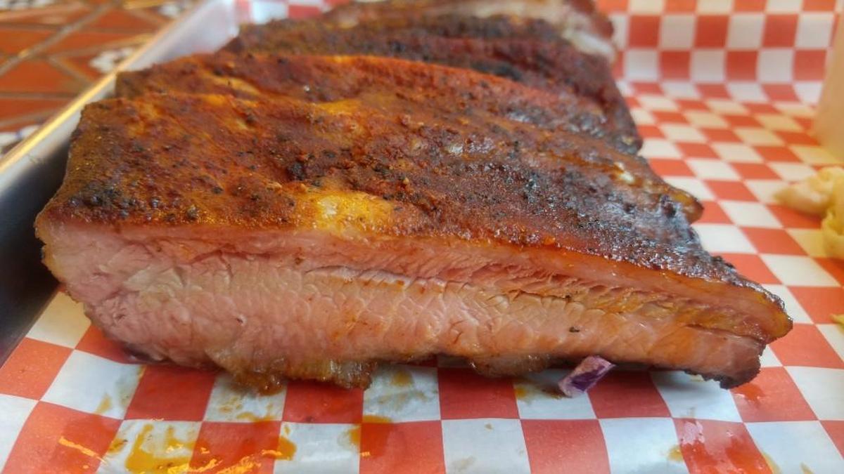 Ribs are rubbed before being smoked at Smokin’ Zee’s BBQ.
