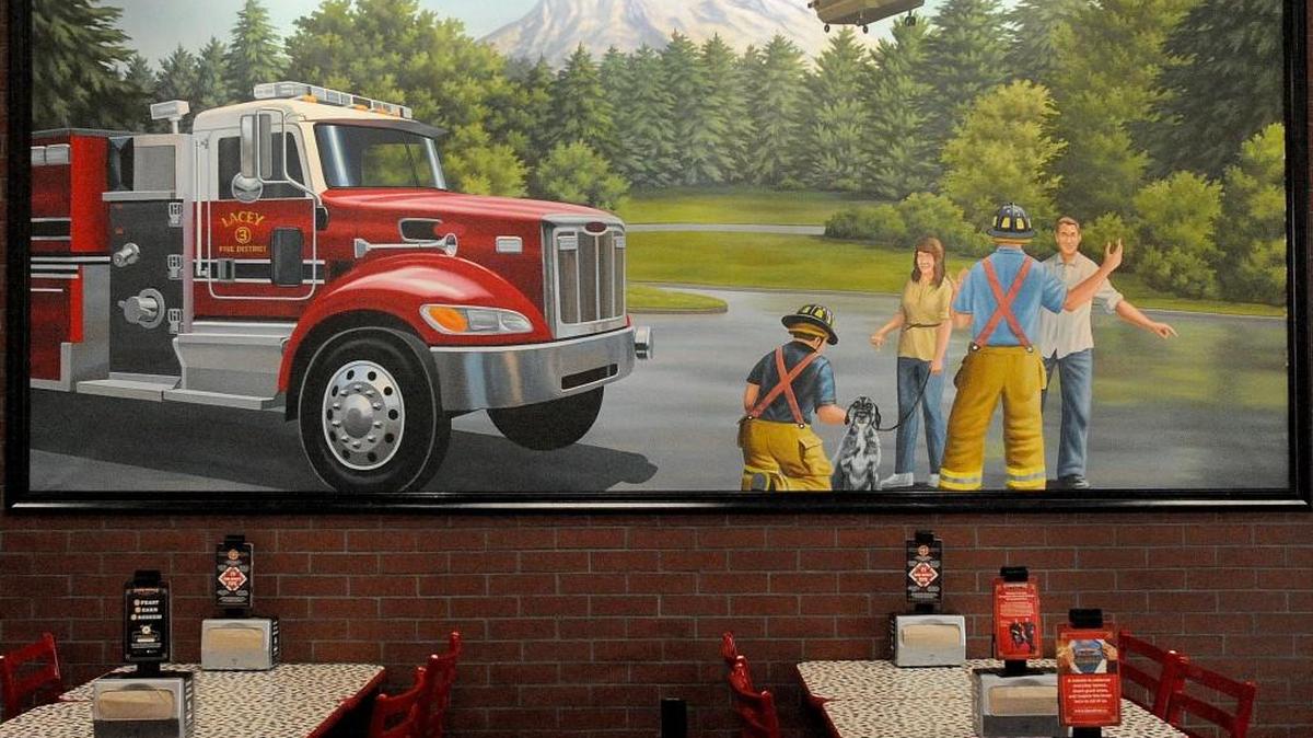 Firehouse Subs opened in Hawks Prairie in 2016 with a mural that carries a Puget Sound theme. The mural depicts a Lacey Fire District engine and a JBLM-based Chinook helicopter, with Mt. Rainier as a backdrop.