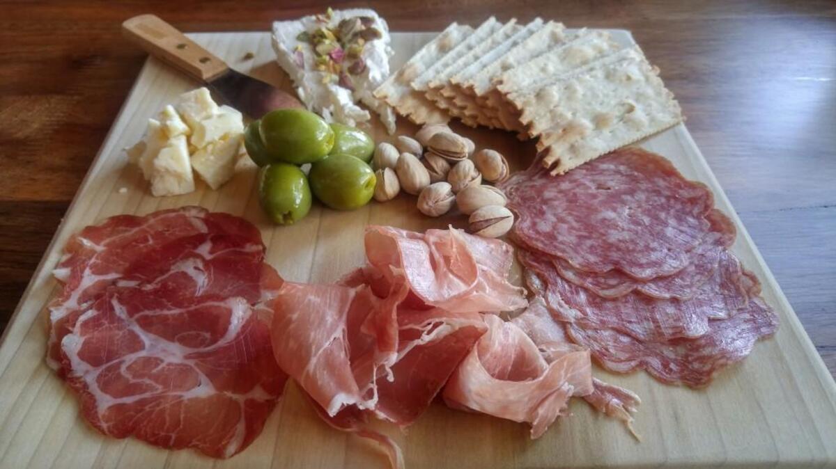 A charcuterie plate with meat, cheese, olives and pistachios, from State Street Beer Co.