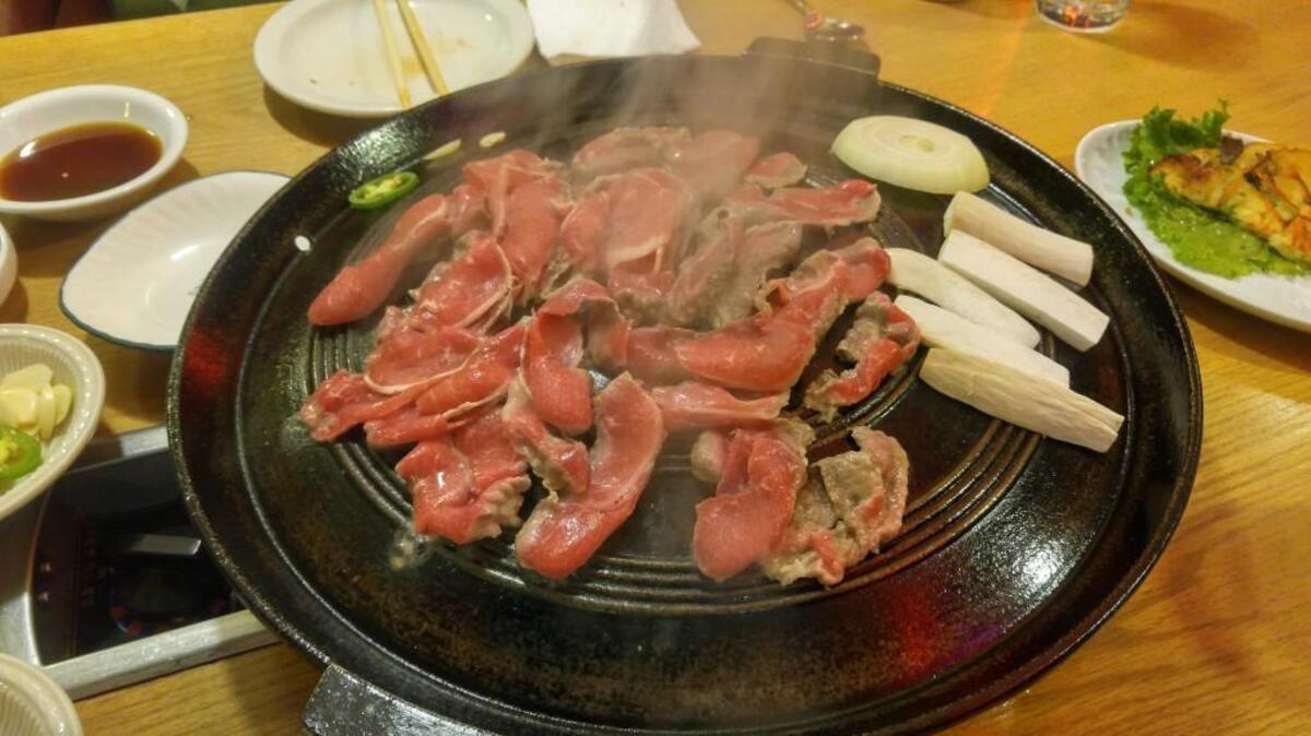 A tabletop barbecue is how meats and vegetables are cooked at a Korean barbecue restaurant.