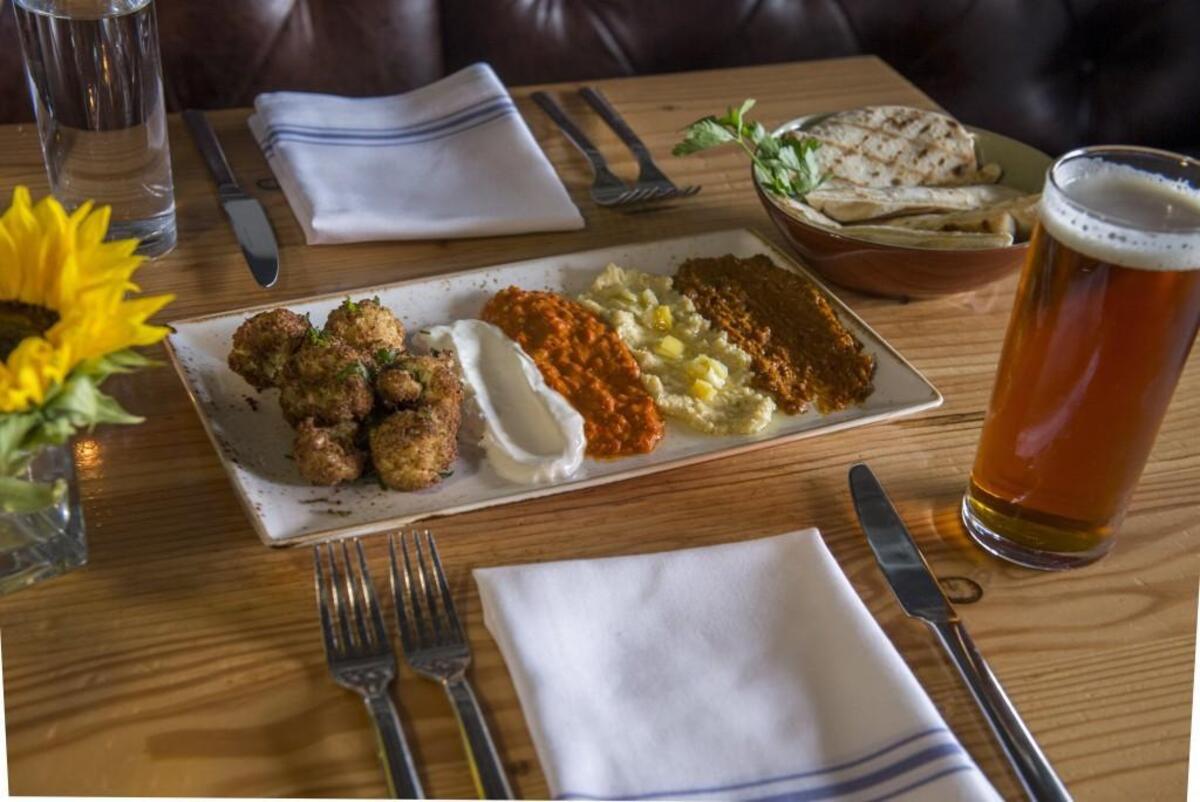 Fried cauliflower at Primo Grill in Tacoma. It comes with four dips: yogurt (left), harissa, hummus and almond piquillo.
