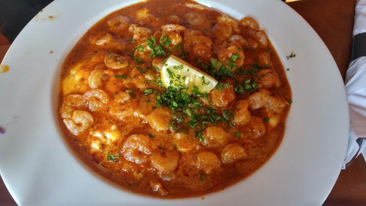 Shrimp and grits are topped with a chile-sauce spiked butter at Bourbon Street Bar and Grill.