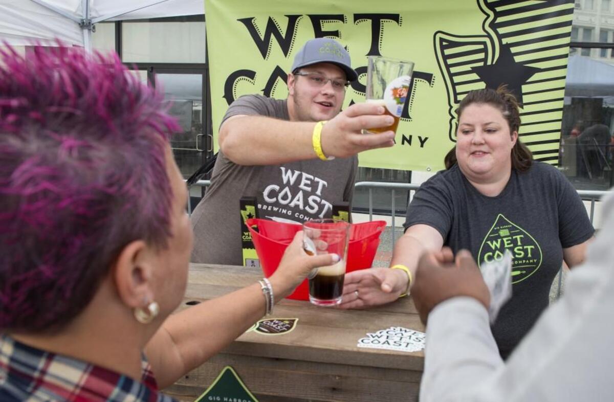 Wet Coast Brewing Co. co-owners Aaron and April Johnson manned a busy pair of taps at their booth at the Brew Five Three beer and blues festival in Tacoma on Aug. 8, 2015.