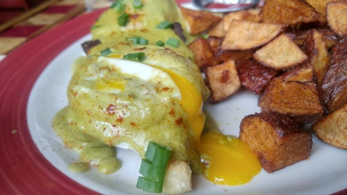 Poached eggs on the pork belly Benedict poured yolk onto the plate.