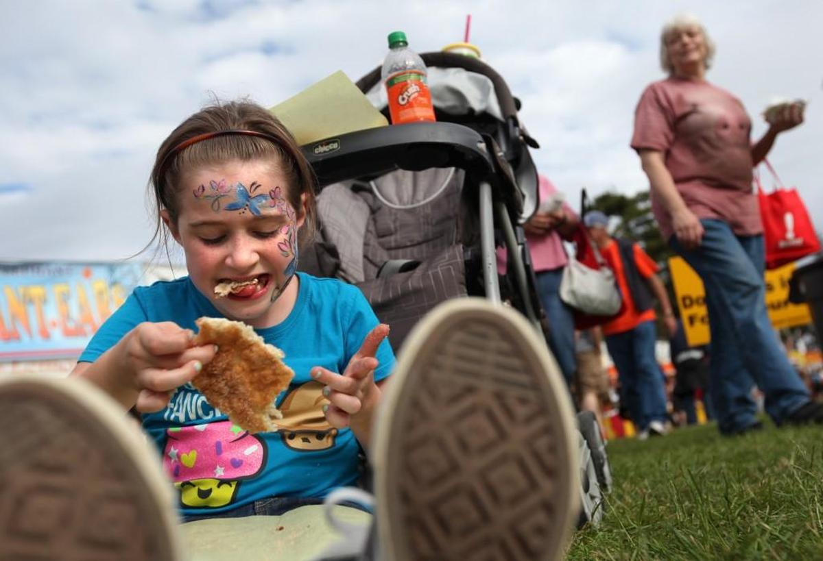 Jewelia Regal devours an elephant ear, during Taste of Tacoma, at Point Defiance Park in Tacoma on June 29, 2012. The parent company of the popular summer event folded in 2020, but the Washington State Fair has resurrected the concept as The Taste Northwest in Puyallup.