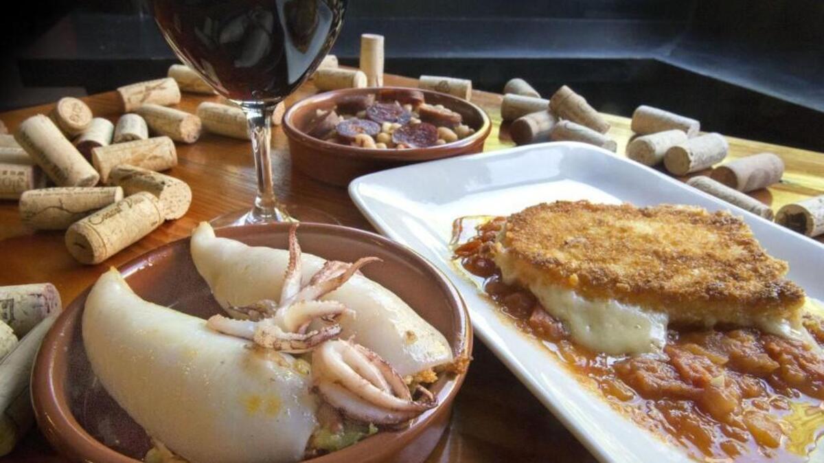 Chorizo stuffed calamariat, left, fried mahon cheese with tomato sauce, right, and white beans with chorizo, back center, at El Tufo in Tacoma. Of the three dishes, the fried cheese stays on the new menu that just debuted at the restaurant.