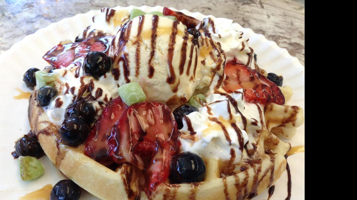 
A waffle at Cafe Amasia is topped with ice cream, whipped cream, fresh berries and chocolate syrup. 

