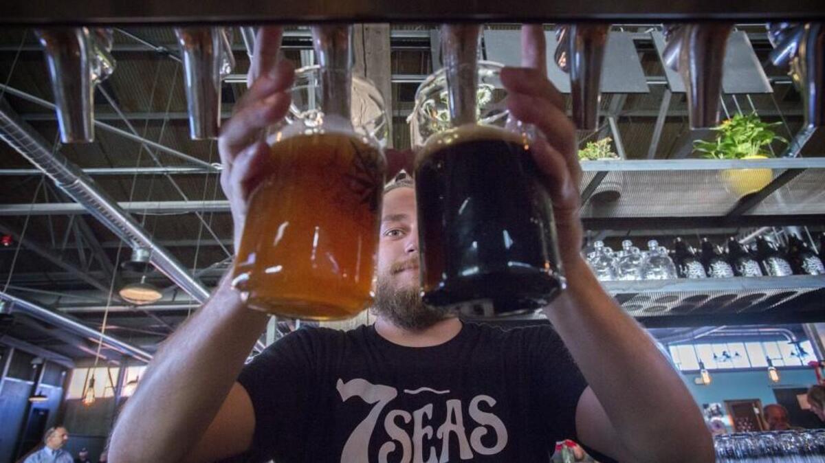 Bartender Grant Colombini pours two beers at 7 Seas Brewing’s Tacoma location. The Gig Harbor-based brewery will serve at the South Sound Craft Beer Festival at the Tacoma Dome.