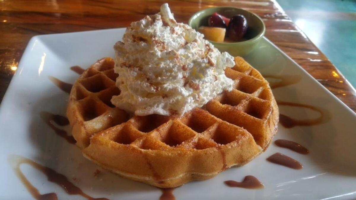 The churro waffle at Montamara Kitchen is dusted with crunchy cinnamon sugar and topped with whipped cream.
