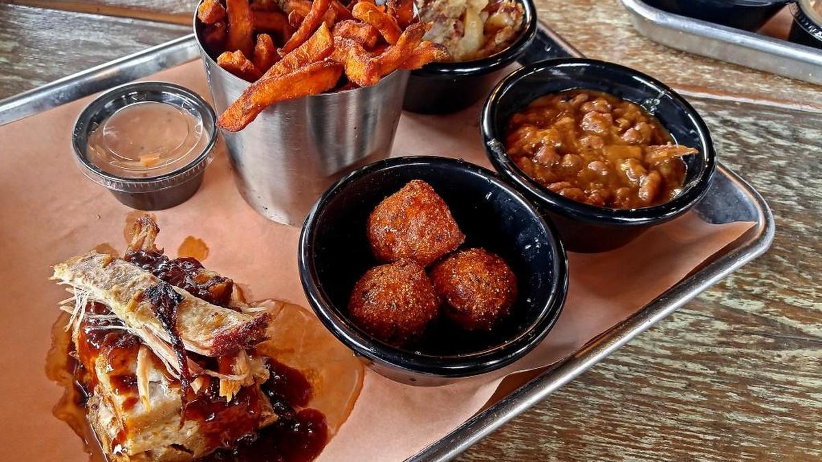 A platter of slow-cooked pork belly and sides at Roasthouse by Arista.