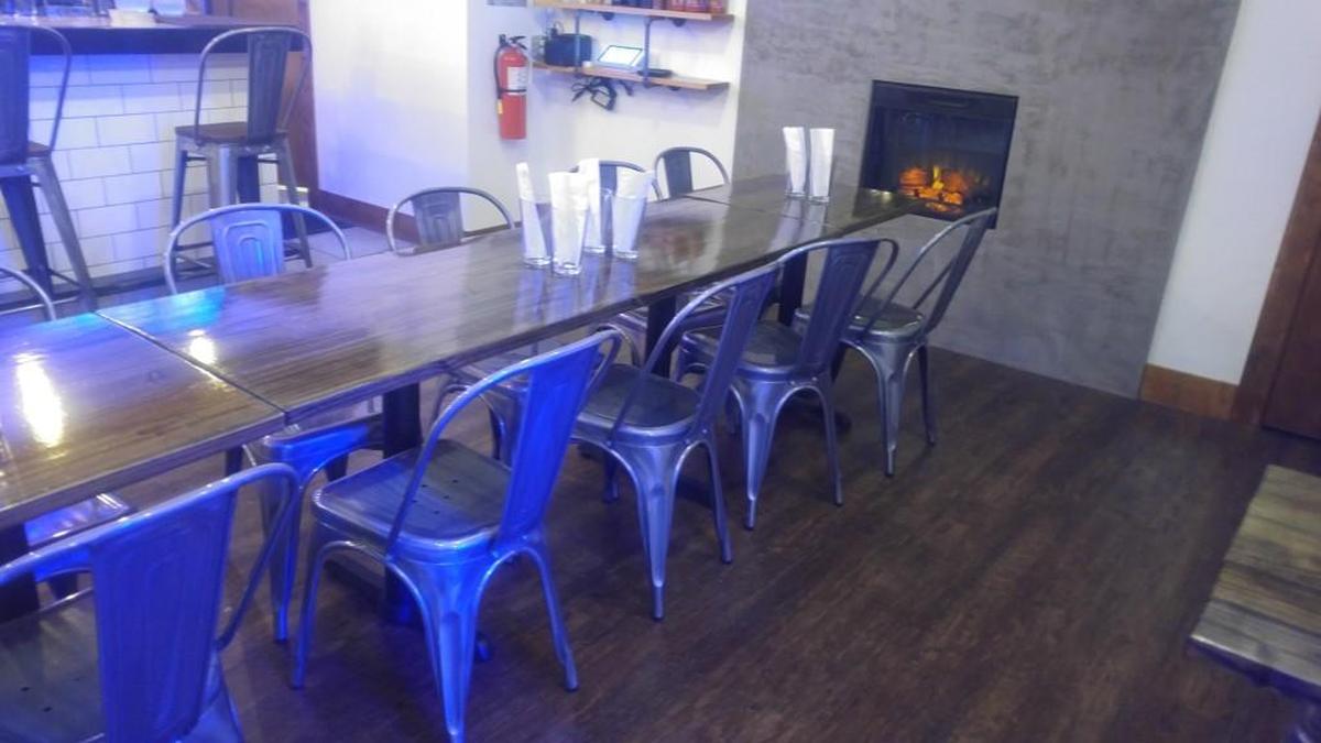 Find a cozy fireplace in the corner next to a large communal table at La Cà Bar.