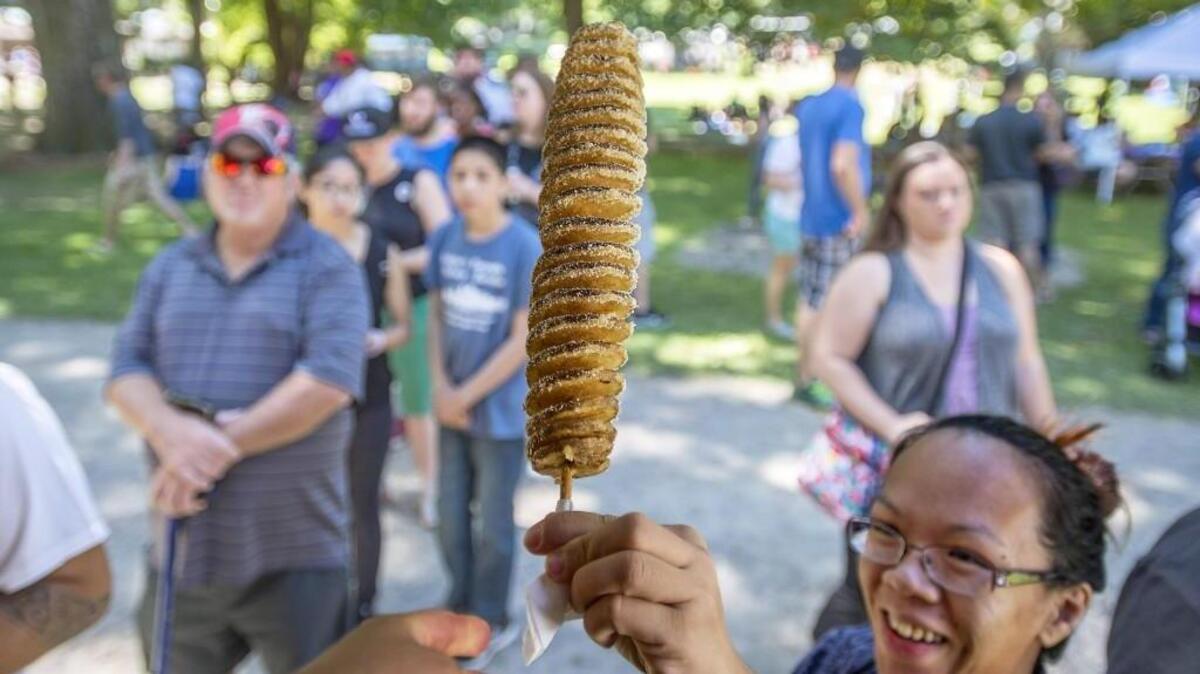Ceceila Cal of Tacoma picks up a Tornado Potato at Metro Parks Tacoma’s Food Truck Fest 2016 at Wright Park.