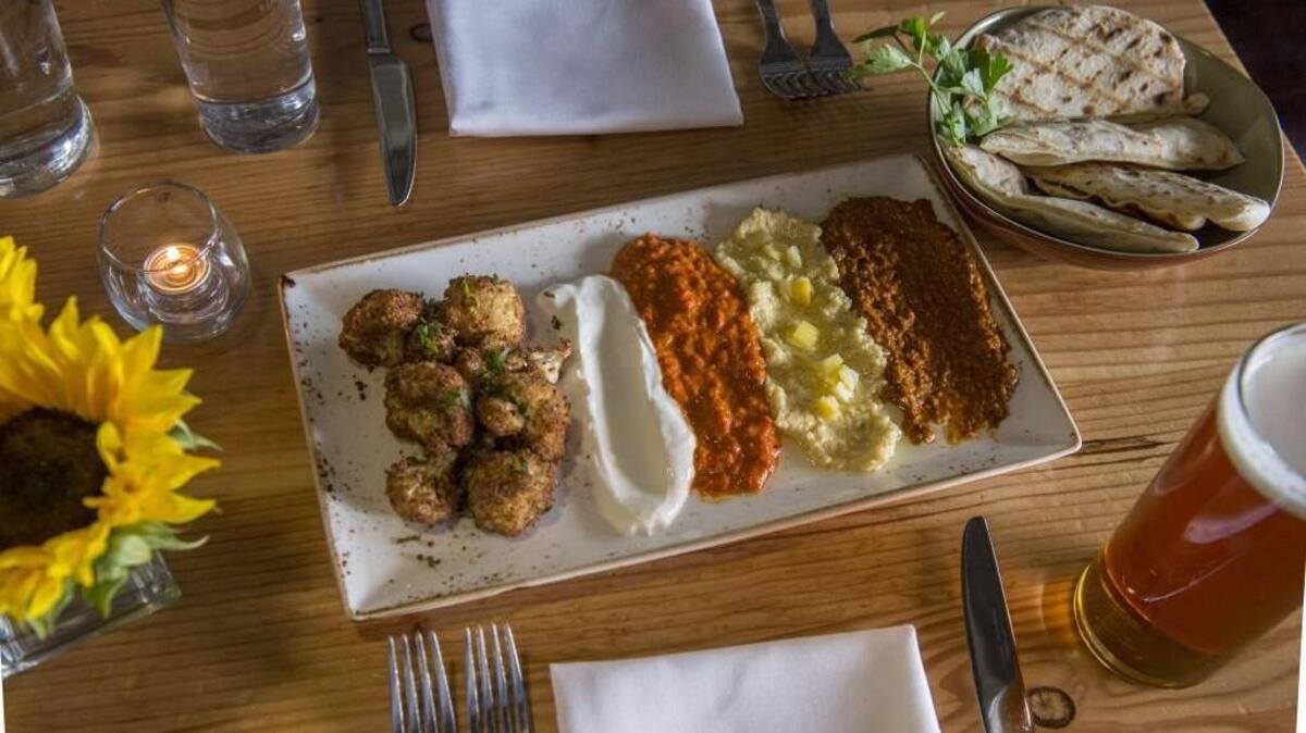 Fried cauliflower at Primo Grill in Tacoma. It comes with four dips: yogurt (left), harissa, hummus and almond piquillo.