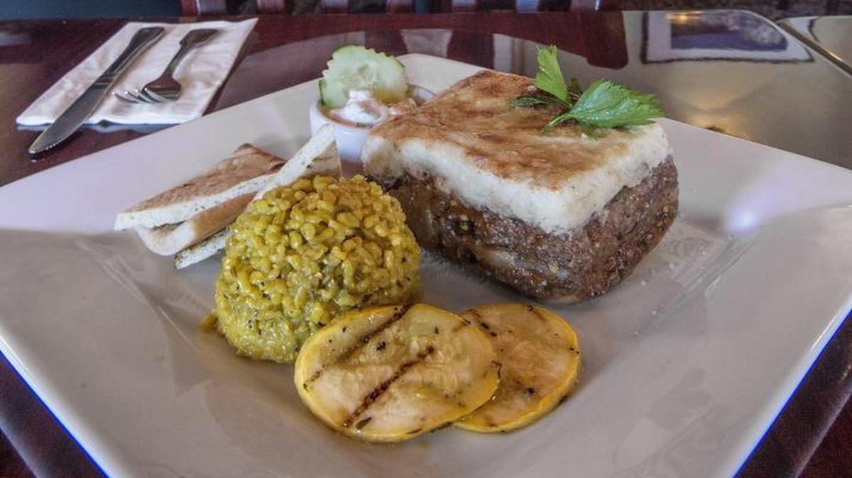 
Traditional Greek Moussaka, with layers of meat and eggplant topped with a Bechamel sauce, is accompanied by rice and sauteed vegetables at Ammar’s Mediterranean Grill in Tacoma on Sept. 23.
