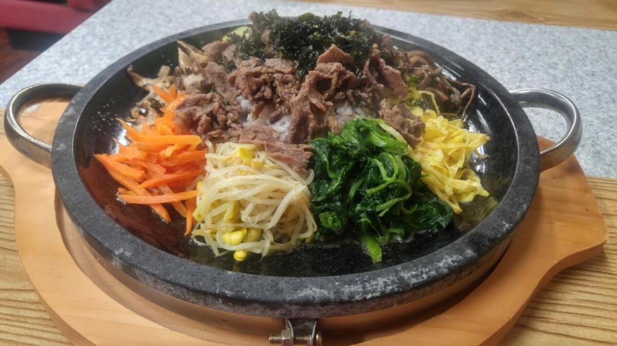 Bibimbap at Sa Rit Gol in Lakewood comes on a flat platter that’s sizzling hot.