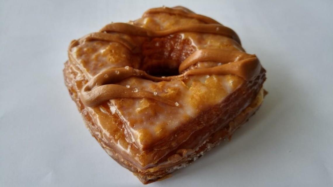 A salted caramel Doughsant, a hybrid of a doughnut and croissant, is a specialty at Legendary Doughnuts.