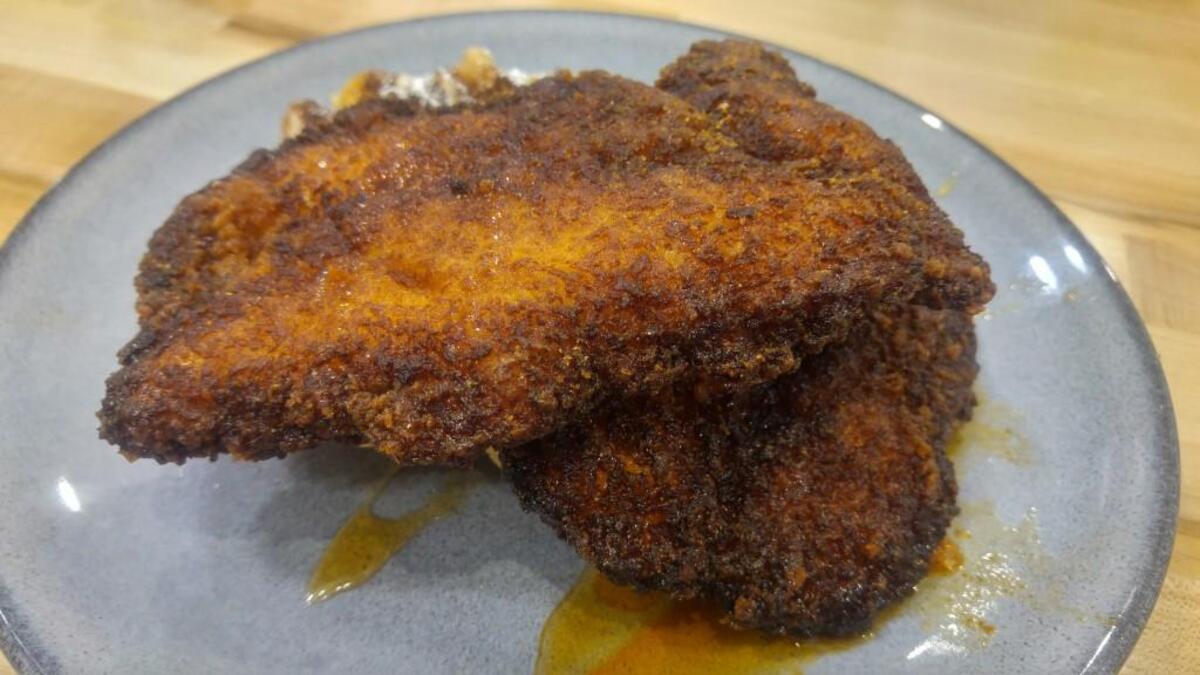 Hot chicken, breaded chicken breast in a spicy breading, is served with a sweet waffle at Waffle Stop.