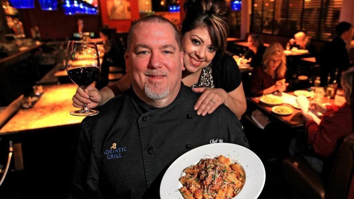 Adriatic Grill co-owners, Bill and Monique Trudnowski, with a plate of bolognese. Monique decided to marry Bill after she tasted his classic Italian dish.