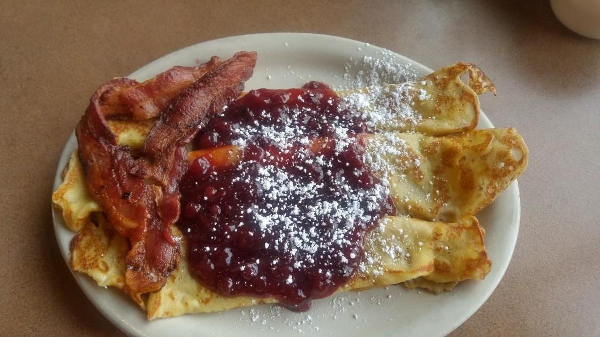 The Harvester Tacoma serves a generous plate of crepes with lingonberries and crispy bacon.