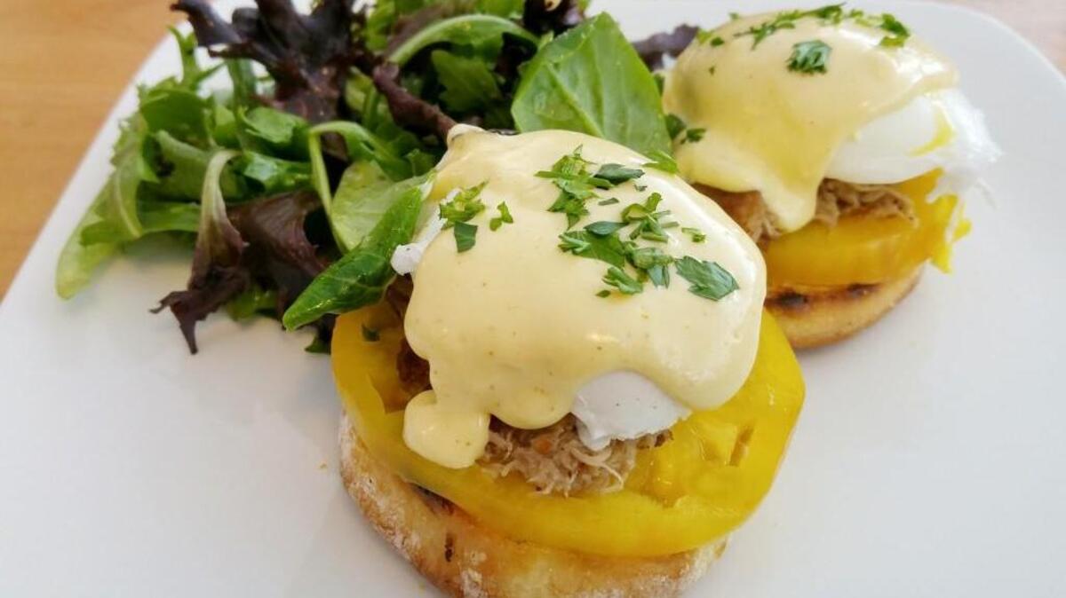 A duck confit Benedict at Cooks Tavern comes with crunchy English muffins and slices of heirloom tomatoes, with a citrus hollandaise.