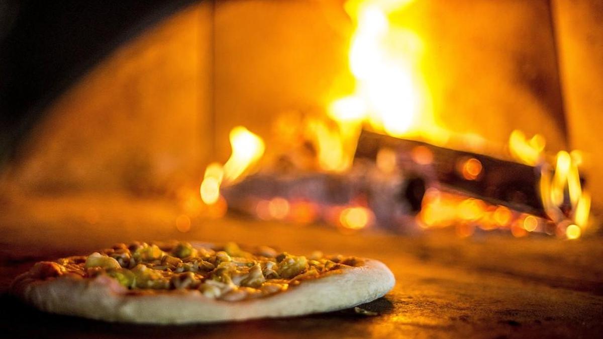 
A Hawaiian pizza cooking in the wood-fired oven at Elemental Pizza, 1702 Pacific Avenue, Tacoma, Wednesday Oct. 7, 2015.
