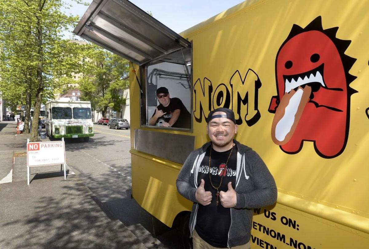 Viet Nom Nom co-owners Andy Huynh, right, and Chris Wetzler, were thumbs up after selling out during the first-ever food-truck rally on Market Street in Tacoma on May 1, 2015. Viet Nom Nom specializes in bahn mi sandwiches and rice bowls. They’ll return to serving this summer at local festivals following an accident that damaged their truck.
