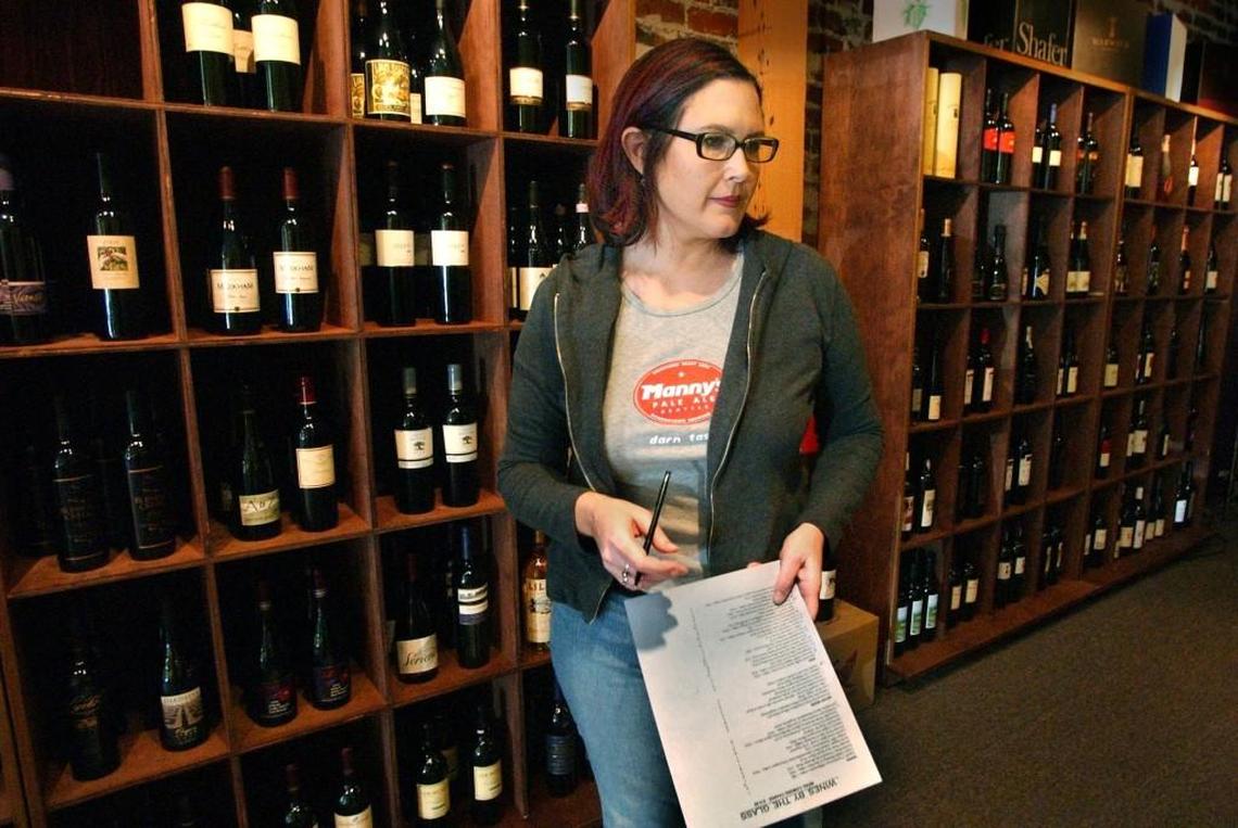 Kris Blondin, owner of Vin Grotto Wine and Cafe in downtown Tacoma, checks the wine inventory of her business in this 2005 photo.