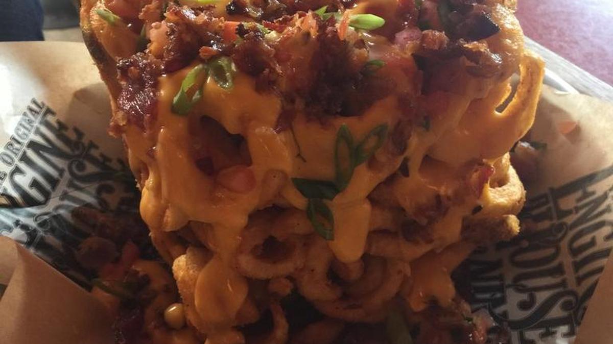 
Brickhouse fries ($8.99), which is a block of seasoned curly fries topped with cheddar cheese sauce, bacon, pico de gallo and green onions, at Engine House No. 9 in Tacoma.
