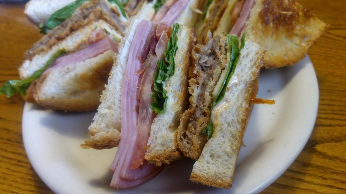 A Cowboy Club is built with crunch in mind. Bacon and ham are on top and chicken fried steak is on the bottom.