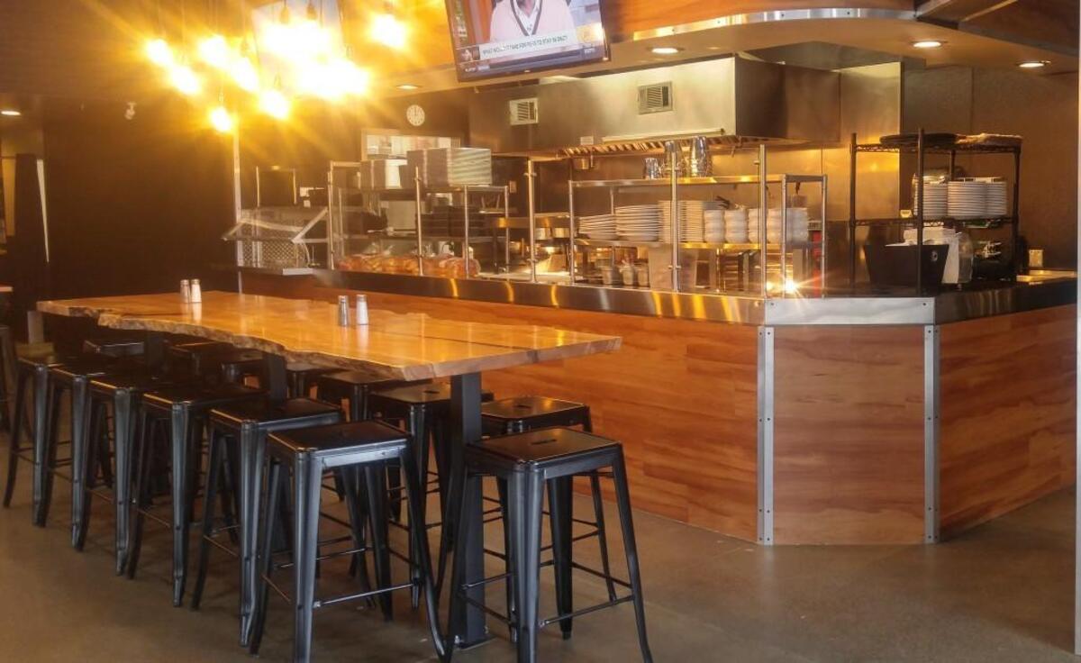 The dining room of Burche holds a community table with a natural edge and seating for about 16.