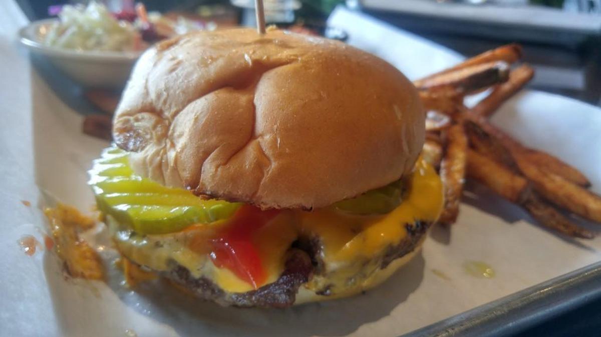 The American Joe burger with American cheese, ketchup, diced onions and pickles at Cole’s Bar and Grill. The burgers are charbroiled at the Ruston restaurant and bar.