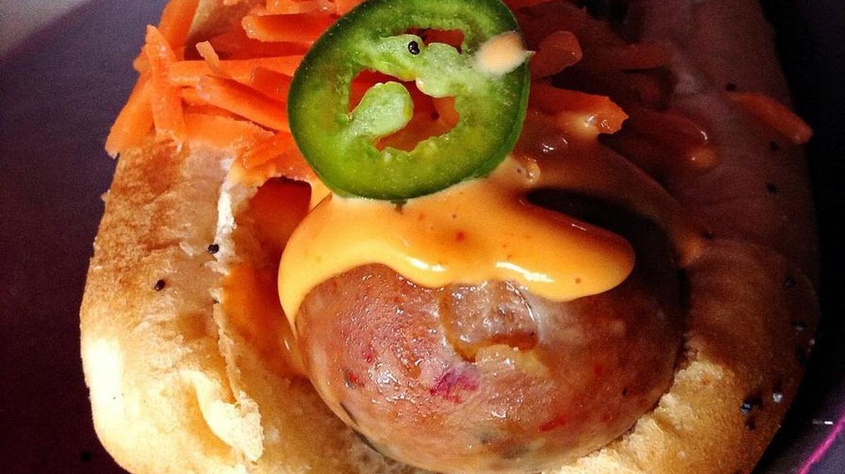The housemade Vietnamese pork sausage at The Red Hot in Tacoma is flavored with jalapeños and fish sauce. It’s served on a hog dog bun with condiments similar to those found on a banh mi sandwich.