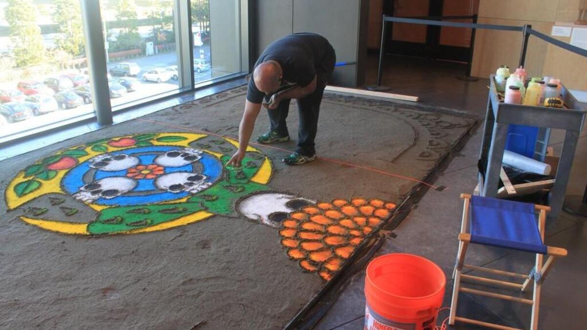 Artist Rene Julio creates a tapete (sand painting) in the lobby of Tacoma Art Museum for Dia de los Muertos.